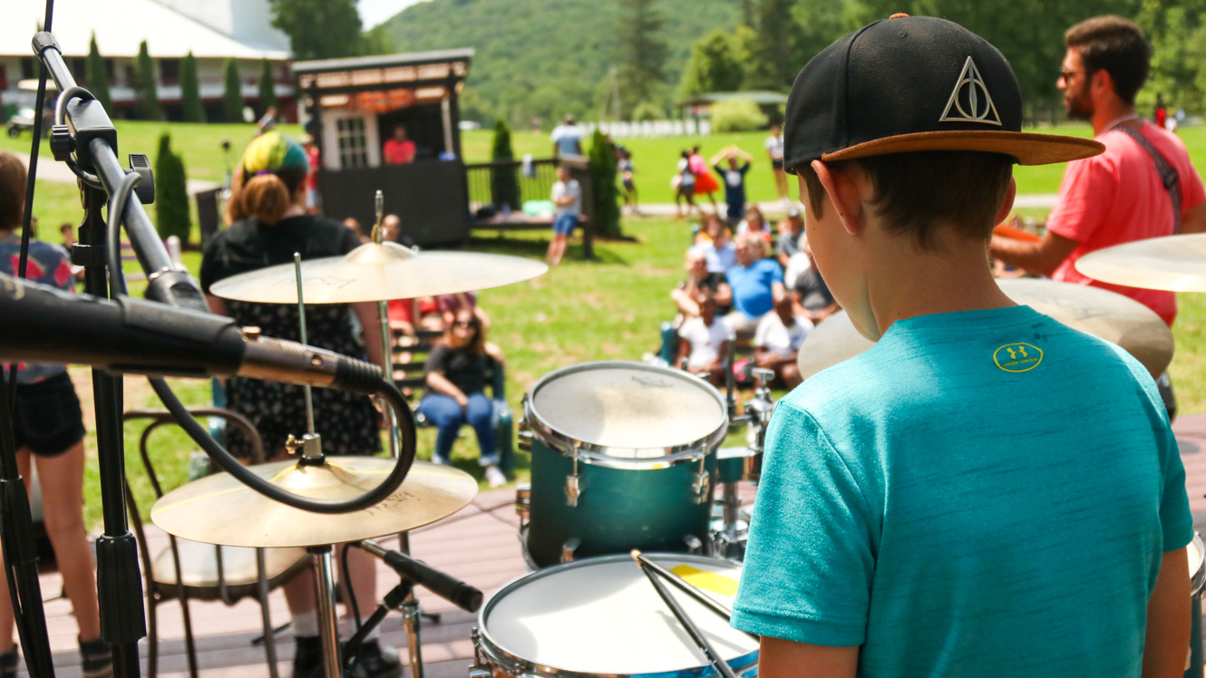 Camper performs on drums in front of audience